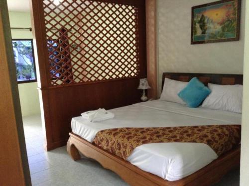 a bedroom with a bed with a wooden head board at Nayai Resort in Chalong