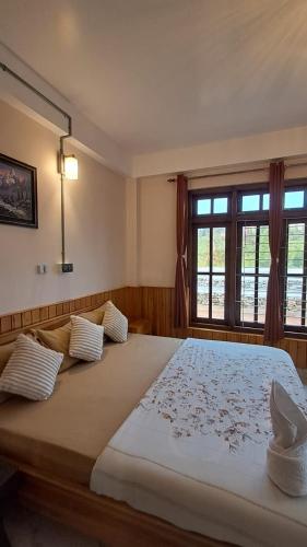 a bedroom with a large bed and a window at Red Cherry Homestay, Nokdara in Lava