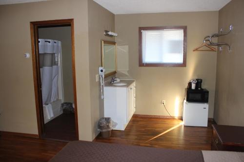 Cette chambre comprend une cuisine équipée d'un réfrigérateur et d'un four micro-ondes. dans l'établissement Eastwood Inn of Wadena, à Wadena