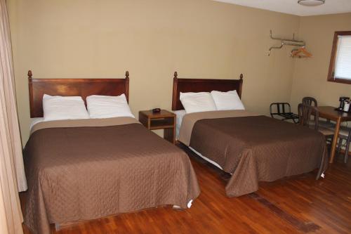 Habitación de hotel con 2 camas y mesa en Eastwood Inn of Wadena, en Wadena