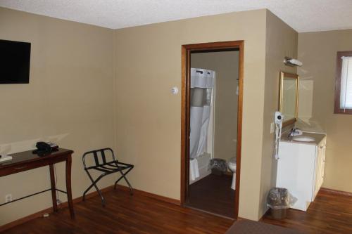 una habitación vacía con una puerta que conduce a un baño en Eastwood Inn of Wadena, en Wadena