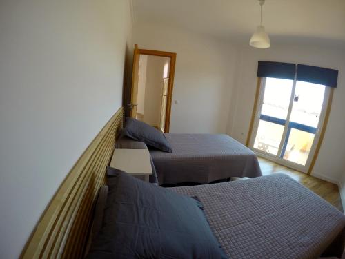 a bedroom with two beds and a window at Cotillo Beach & Sport in Cotillo