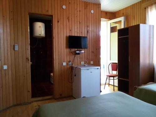 a room with a refrigerator and a tv in it at Villa Ureki in Ureki