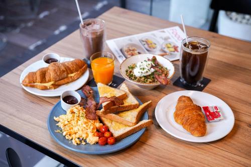 a table topped with plates of breakfast foods and drinks at Shama Lakeview Asoke Bangkok in Bangkok