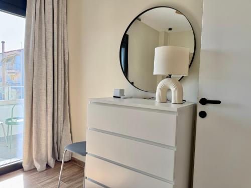a mirror on top of a dresser with a lamp at Azur Mare Luxury Villas in Neoi Epivates