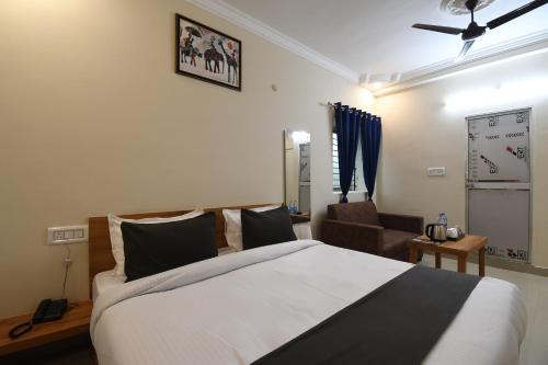 a bedroom with a large bed and a chair at Hotel Sonnet Inns in Rānchī