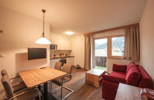 a living room with a red couch and a table at Ferienhaus Larinmos in Lermoos
