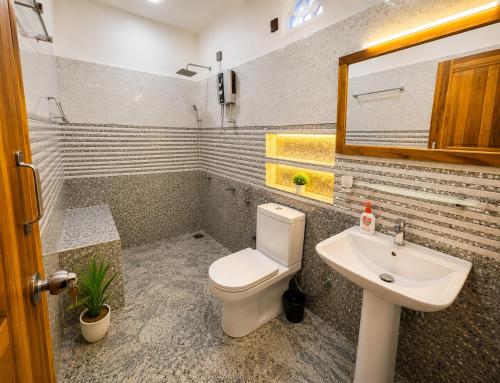 a bathroom with a toilet and a sink at Beach Wave Hotel in Arugam Bay