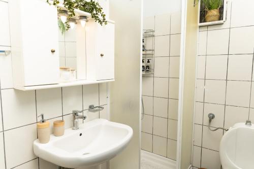 a white bathroom with a sink and a mirror at Touzla Blue Heaven in Orfánion