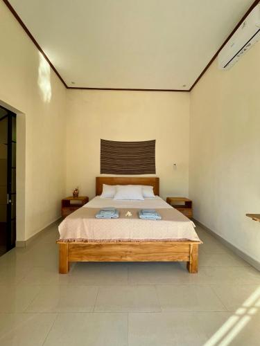 a bedroom with a large bed with two towels on it at Di rumah Vima homestay in Pemuteran