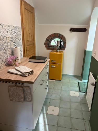 a kitchen with a counter and a yellow refrigerator at Appartment Casa Verde in Lübberstedt