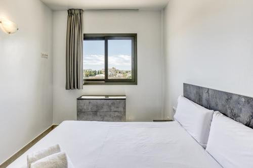 a bedroom with a white bed and a window at Giuliano Superior 4 personas in Empuriabrava