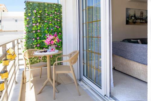 a small table and chairs on a balcony with flowers at Christina's House in Afantou