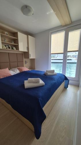a bedroom with a large bed with two towels on it at FLOATING SEA HOUSE AURORA in Portorož