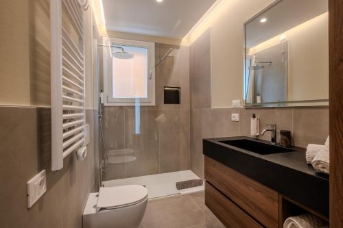 a bathroom with a toilet and a sink and a shower at Residence Lido di Dante in Lido di Jesolo