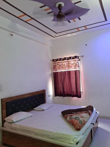 a bedroom with a bed with a ceiling fan at Khaatuwaale Guest House in Khātu