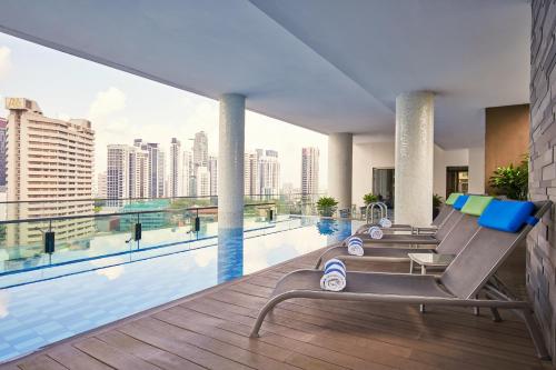 a hotel swimming pool with a view of the city at Quincy Hotel Singapore by Far East Hospitality in Singapore