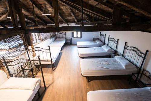 un gruppo di letti in una camera con pavimenti in legno di Albergue Rosalia / Pilgrim Hostel a Castrojeriz