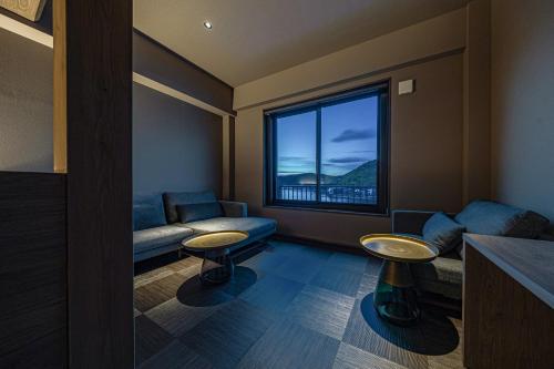 a living room with a couch and a large window at 中尾甚六Hotel in Karatsu
