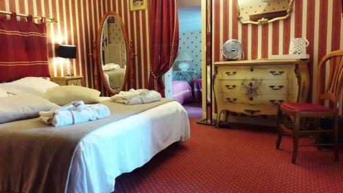 a bedroom with two beds and a dresser and a mirror at LOGIS - Hôtel & Restaurant Le Gonfalon in Germigny-lʼEvêque