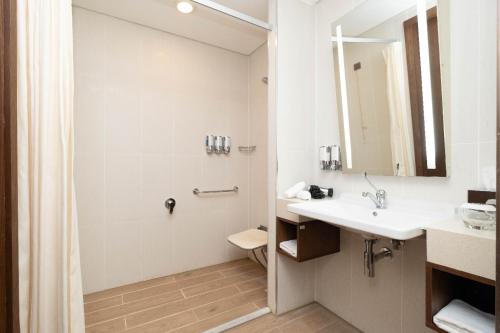 a bathroom with a shower and a sink and a toilet at Hampton by Hilton Samsun in Samsun