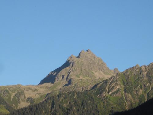 a mountain with a blue sky in the background at Apartmenthaus Immler in Gaschurn