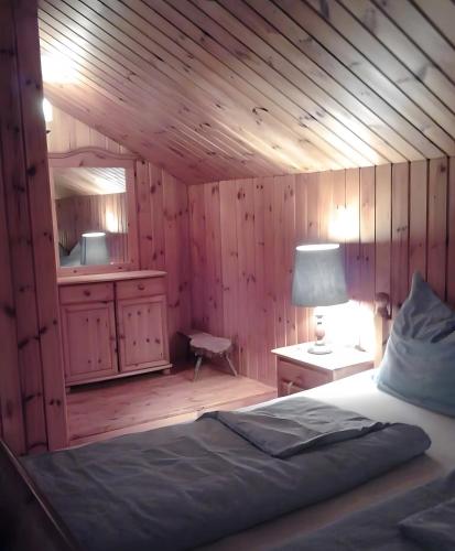 a bedroom with wooden walls and a bed and a lamp at Chalet Adlerhorst am Großglockner in Heiligenblut