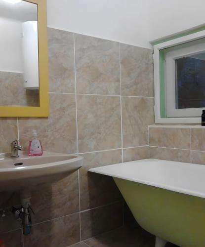 a bathroom with a tub and a sink and a mirror at Chalet Adlerhorst am Großglockner in Heiligenblut