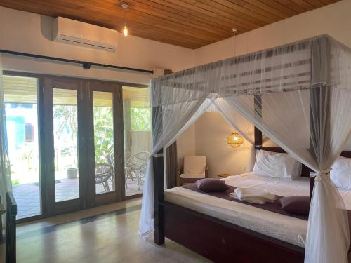 a bedroom with a canopy bed in a house at Villa Flamingo in Ahangama