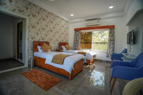 a bedroom with two beds and a window at Jai Ganesha Resort in Chālsa Mahābāri