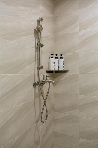 a shower with a hose in a bathroom at soul stay in Busan