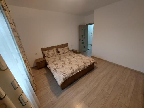 a bedroom with a bed and a wooden floor at Apartament Dem Radulescu Bloc nou! in Râmnicu Vâlcea