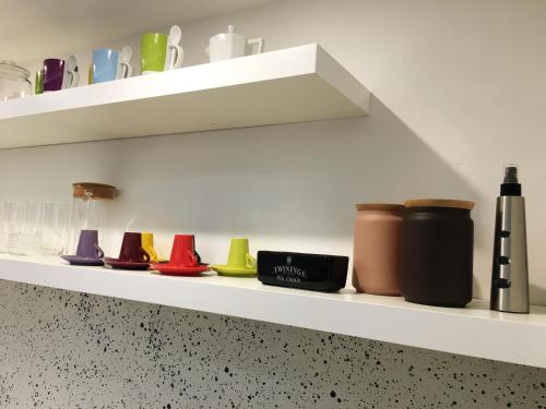 a shelf with different colored vases on it at Costantino Home in Pompei