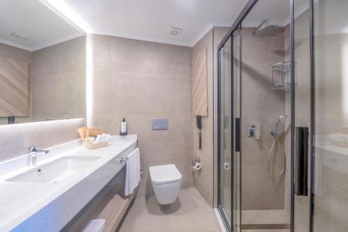 a bathroom with a shower and a toilet and a sink at Royal Atlantis Icon in Side