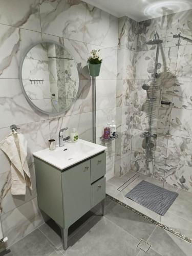 a bathroom with a sink and a shower at Polys Apartment and Paraskevi studio with view in Ptolemaida
