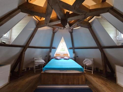 a bedroom with a bed in a room with a window at Le Moulin de Bréhaut in Augan