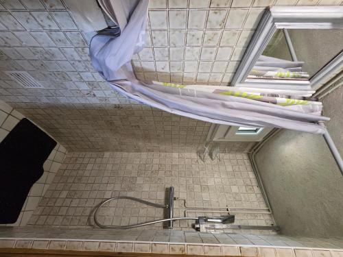 a shower in a bathroom with a shower curtain at Le Moulin de Bréhaut in Augan