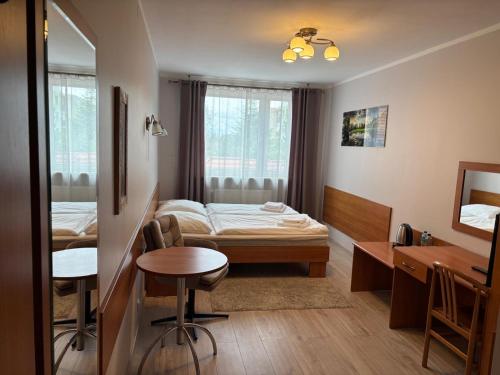 a bedroom with a bed and a desk and a table at Hotel Domino in Głubczyce