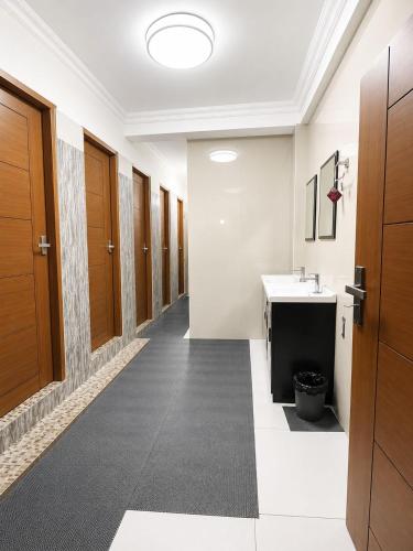 a hallway with wooden doors and a sink at W H Nest Hostel in Cochin