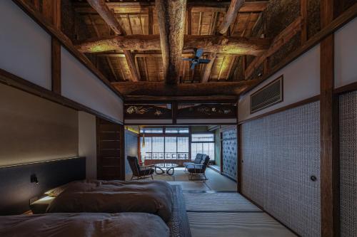 a bedroom with two beds and a wooden ceiling at 中尾甚六Hotel in Karatsu