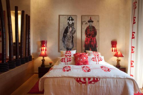 a bedroom with a bed with two pictures on the wall at Tigmiza Boutique Hotel & Spa in Marrakech
