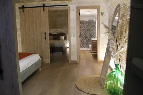a room with a bedroom with a bed and a vase at Dimora Antica Santa Chiara in Trani