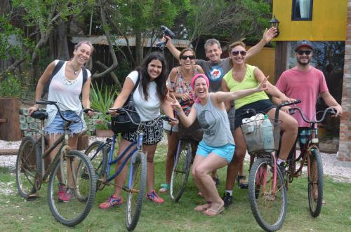 a group of people on bikes posing for a picture at La Brújula Hostel in La Paloma