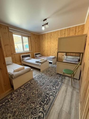 a room with two beds and a rug at Aruna Guesthouse in Saty