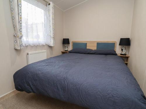 a bedroom with a large bed and a window at Willerby Malton in Ruthin