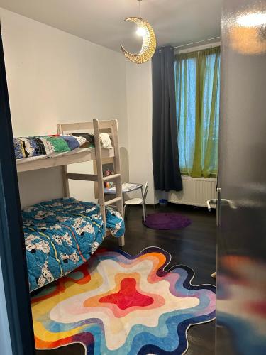 a bedroom with a bunk bed and a colorful rug at Le Néococoon in Neufchâteau