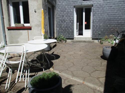 a patio with a table and chairs in front of a building at La Source - 85 m2 & terrasse privée in Orcival