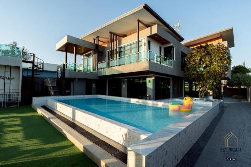 a house with a swimming pool in front of a house at Sky Beach Pool Villa Chanthaburi 1 in Laem Sing