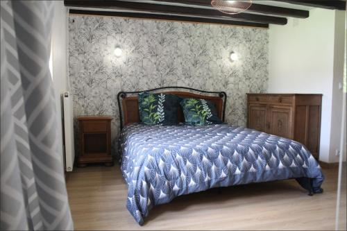 a bedroom with a bed with a blue comforter at Gîte MARISA in Champagney