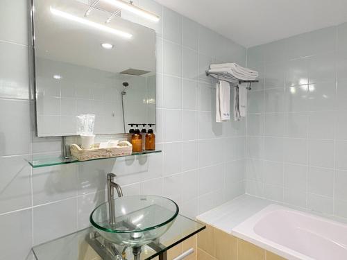 a bathroom with a glass sink and a mirror at NJ INTHAI Hotel in Sathani Chiang Rak